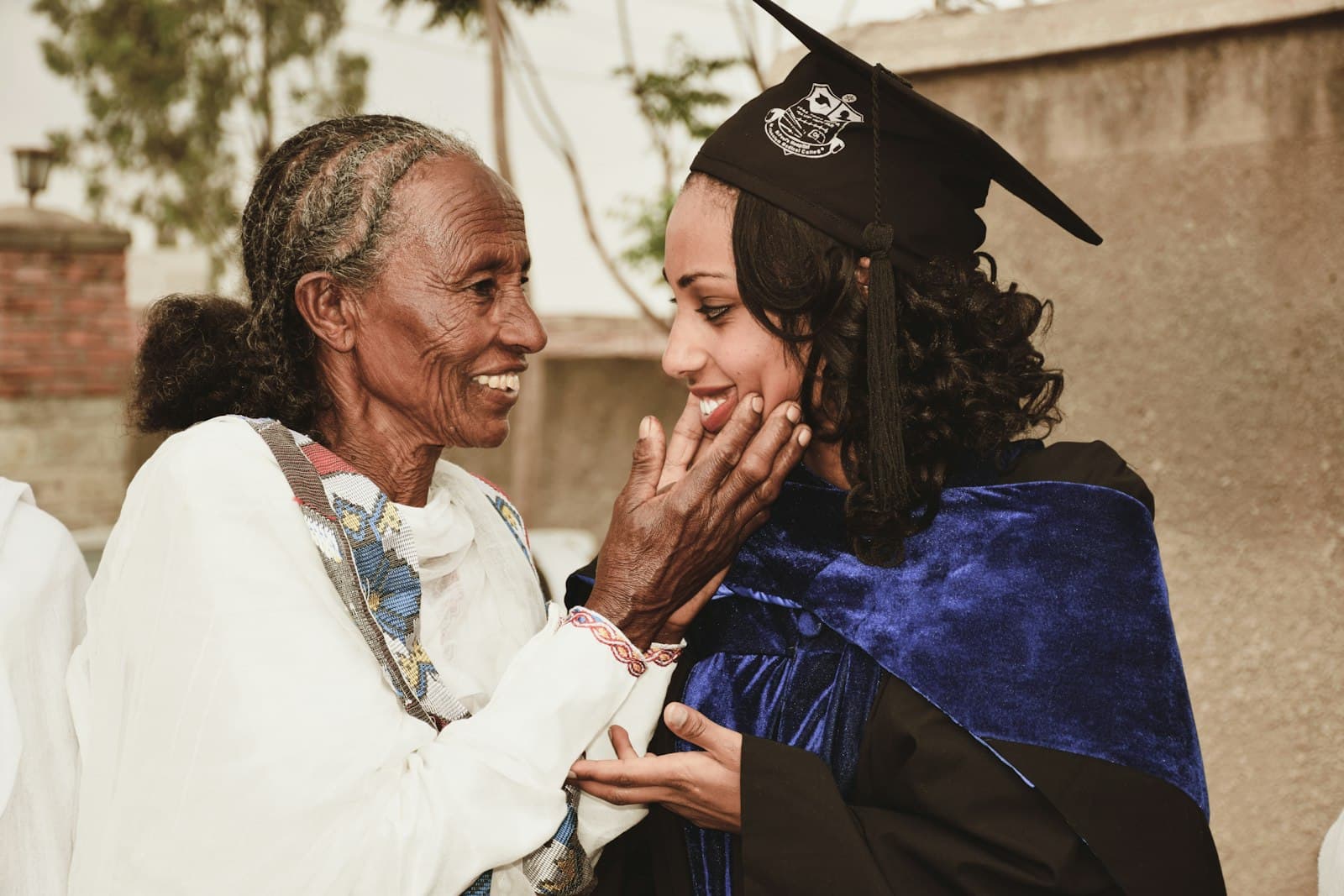 A grandmother in traditional Ethiopian dress congratulating her granddaughter on her graduation in Addis Ababa